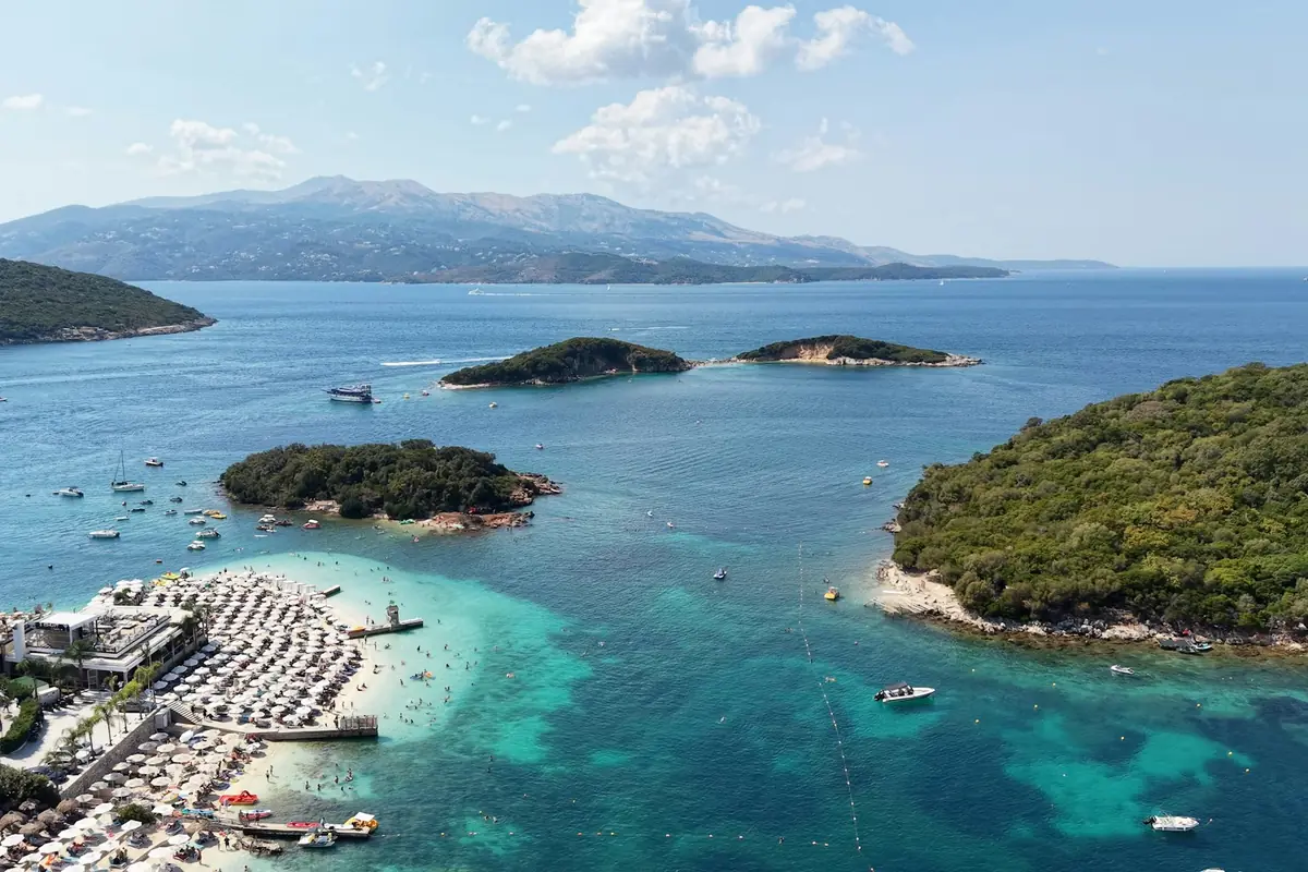 Ksamil sett fra luften med de små skogkledde øyene i turkisblått vann
